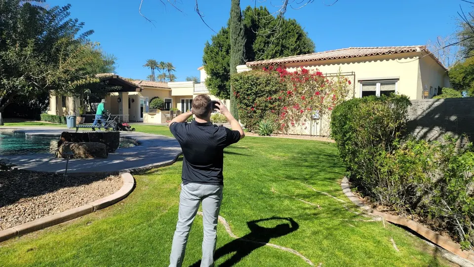 An RSDS appraiser photographing a home exterior and pool during an inspection