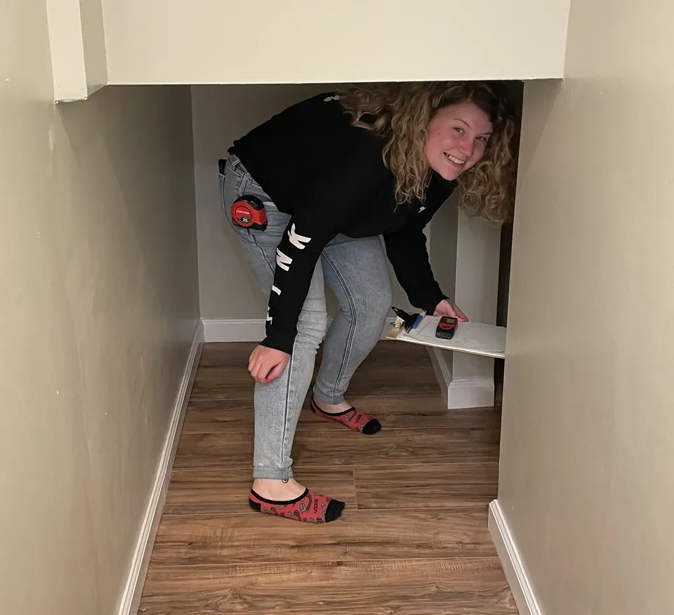 An RSDS appraiser measuring the space under a staircase
