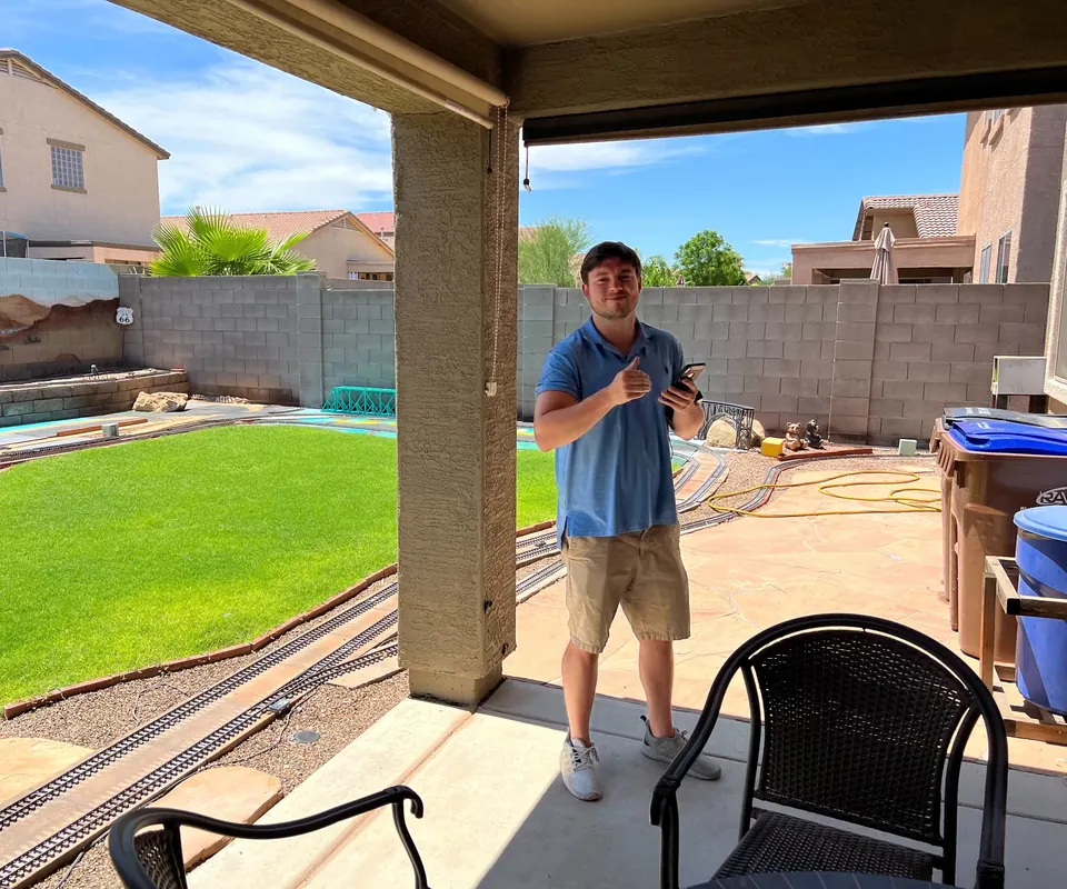 An RSDS appraiser giving a thumbs-up on a backyard patio during an inspection